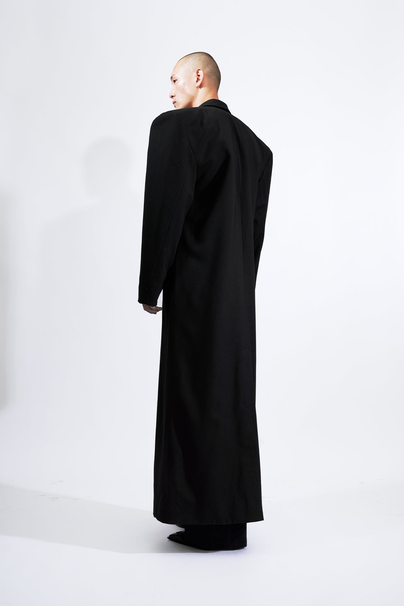 long blazer coat in black wool with exagerated shoulders and lapel