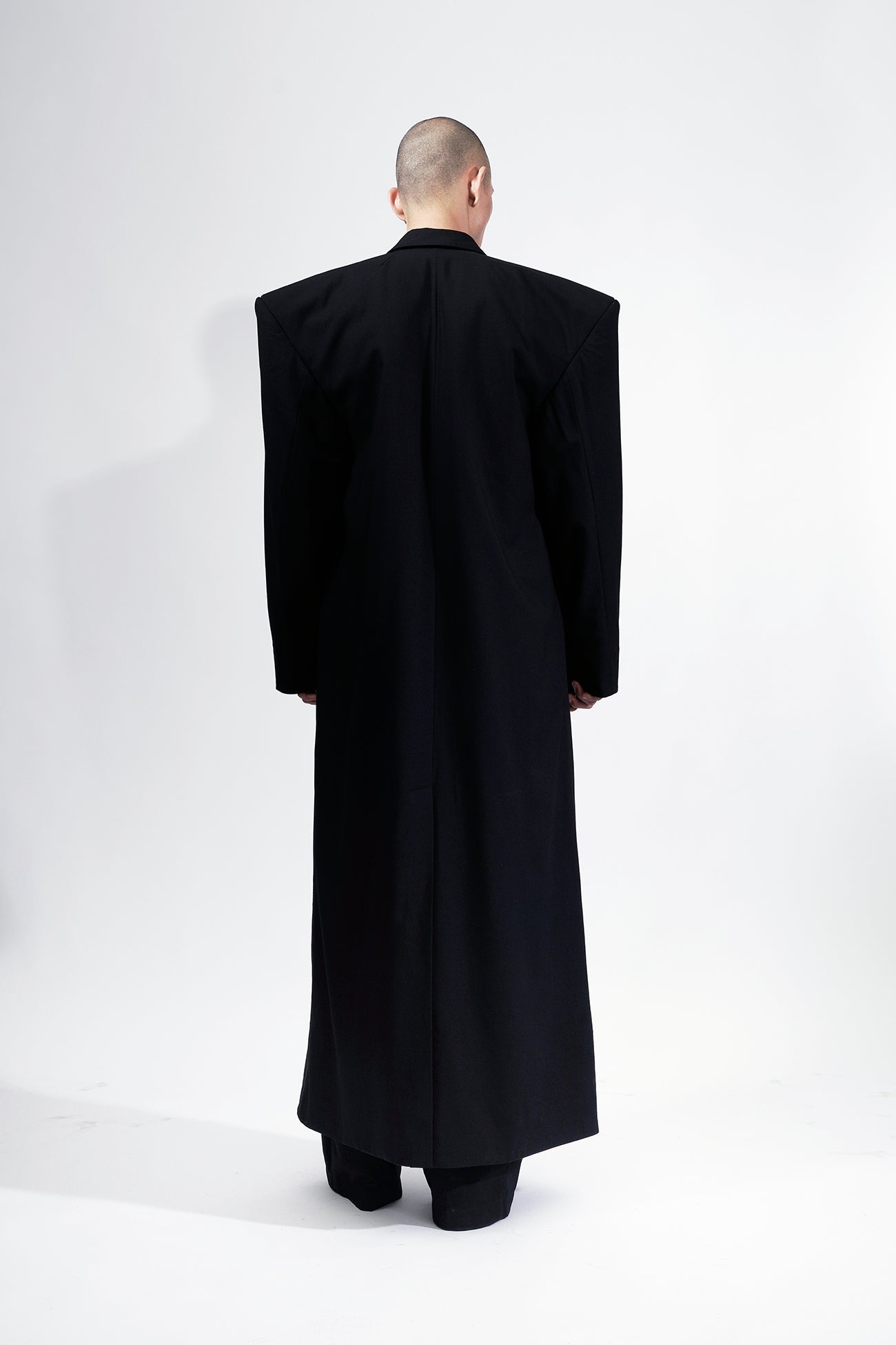 long blazer coat in black wool with exagerated shoulders and lapel