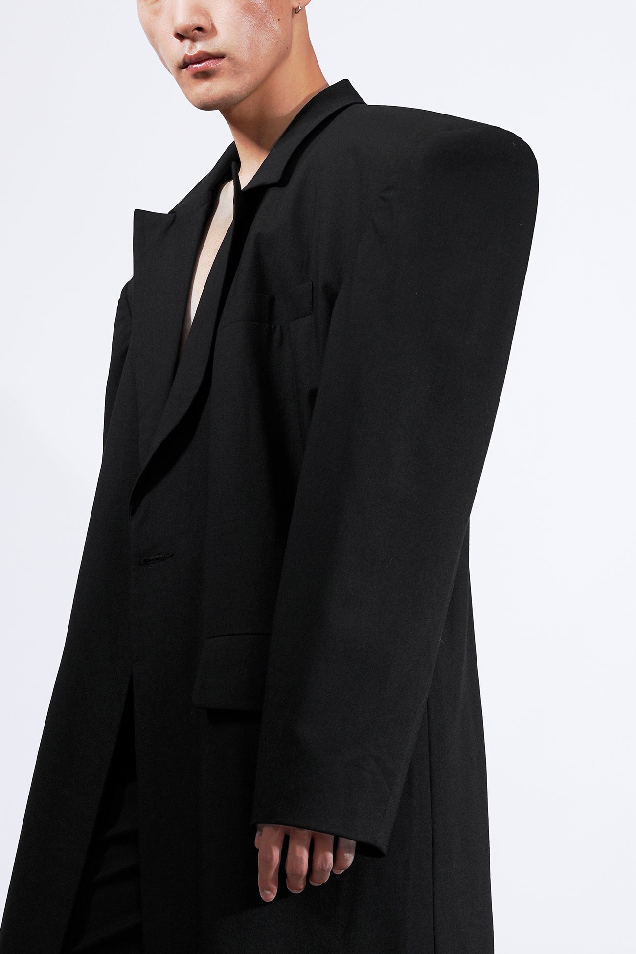 long blazer coat in black wool with exagerated shoulders and lapel