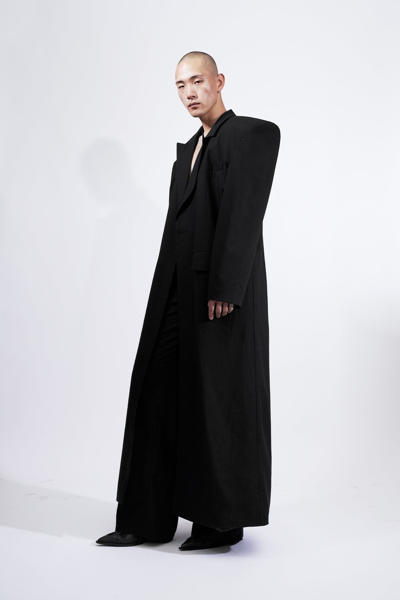 long blazer coat in black wool with exagerated shoulders and lapel