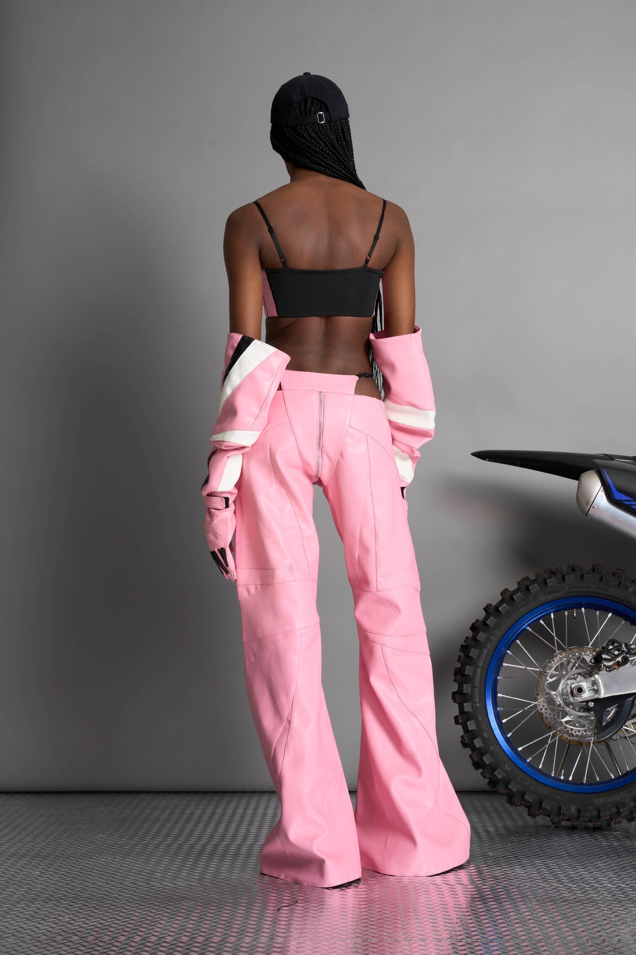 pink vegan leather belt top with three adjustable grommet straps, oversized metal buckles, and circular hardware – edgy bondage-inspired crop top for festival or clubwear.