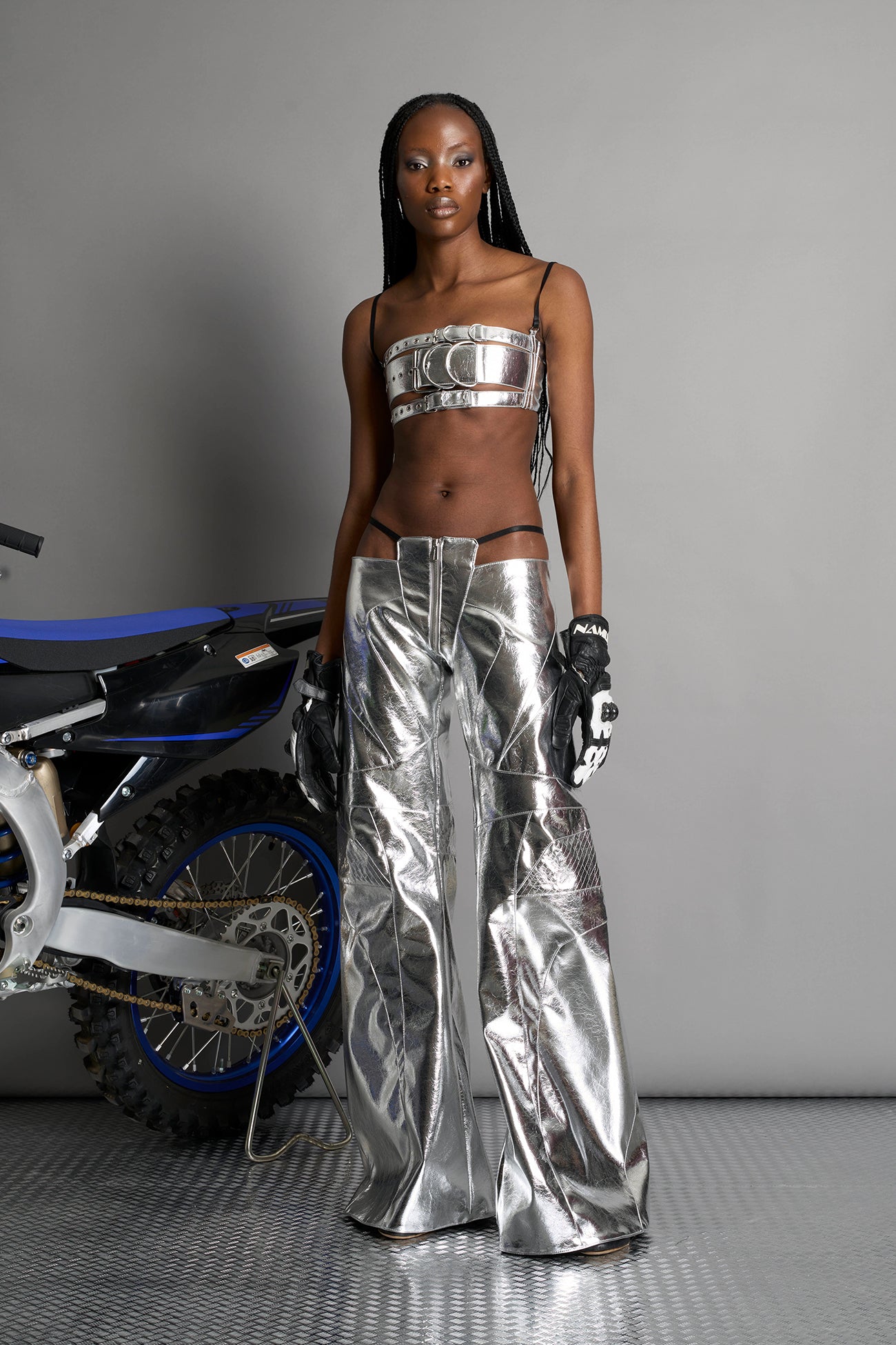 silver vegan leather belt top with three adjustable grommet straps, oversized metal buckles, and circular hardware – edgy bondage-inspired crop top for festival or clubwear.