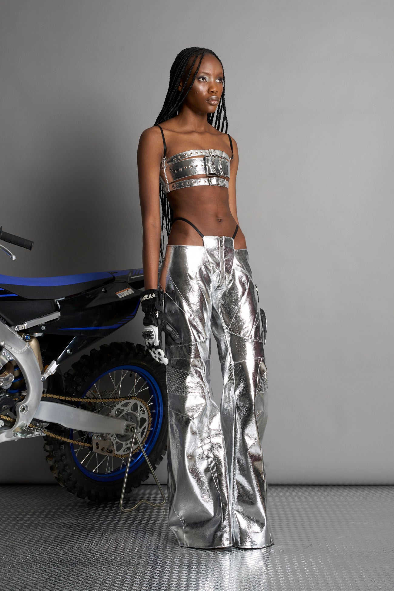 silver vegan leather belt top with three adjustable grommet straps, oversized metal buckles, and circular hardware – edgy bondage-inspired crop top for festival or clubwear.