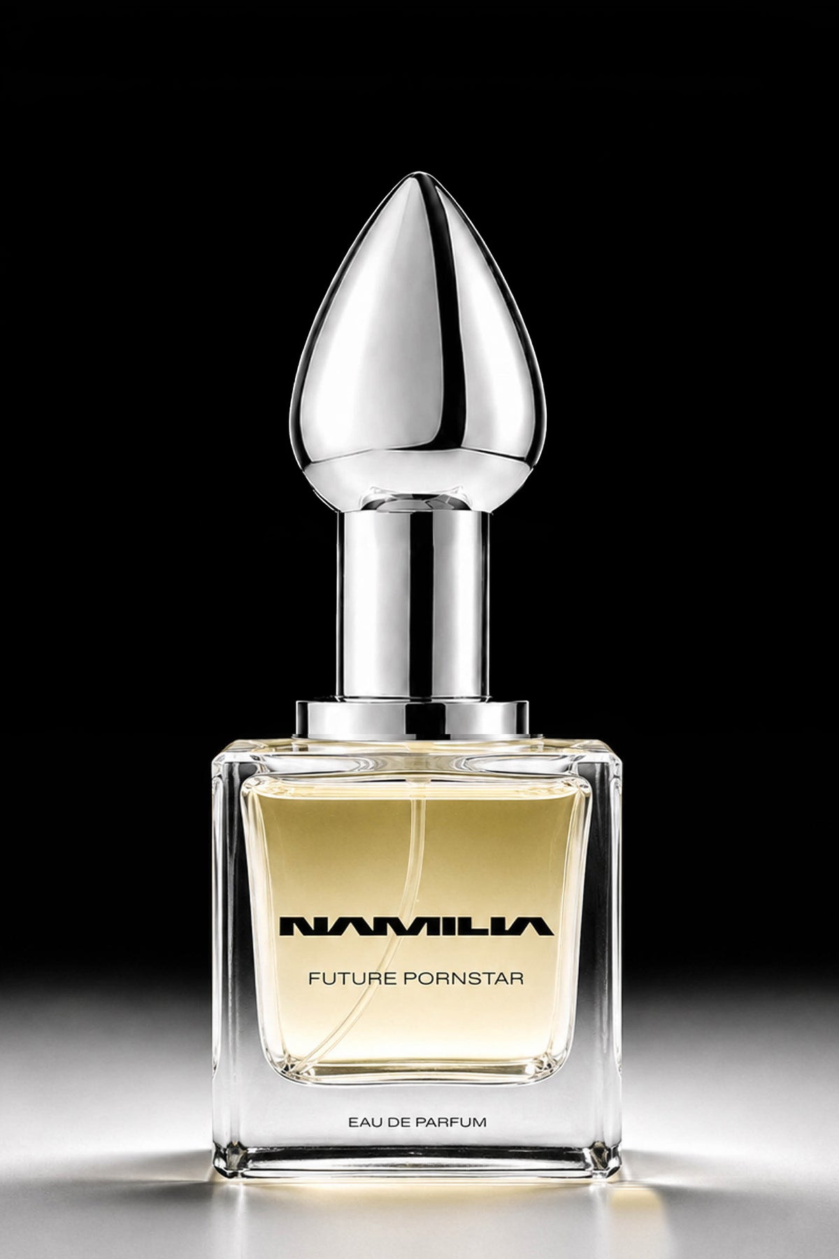 A square glass perfume bottle with pale yellow liquid, a reflective silver neck, and a teardrop-shaped silver cap, centered on a black background. The bottle is labeled 'NAMILIA FUTURE Pornstar EAU DE PARFUM'.