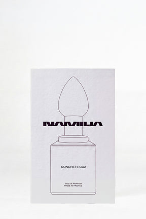 A minimalist white rectangular box for Namilia Concrete CO2 Eau de Parfum, featuring a simple black line drawing of a dropper bottle on a clean white background.