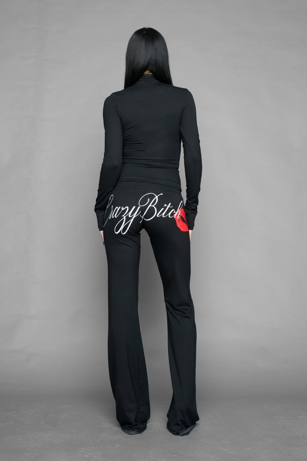 black crazy jersey pants with high waist rib waistband drawstring and back graphic print on model studio ecom photo