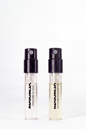 Two small parfum testers. The left vial is labeled 'NAMILIA CONCRETE CO2' and the right vial is labeled 'NAMILIA FUTURE PORNSTAR'.