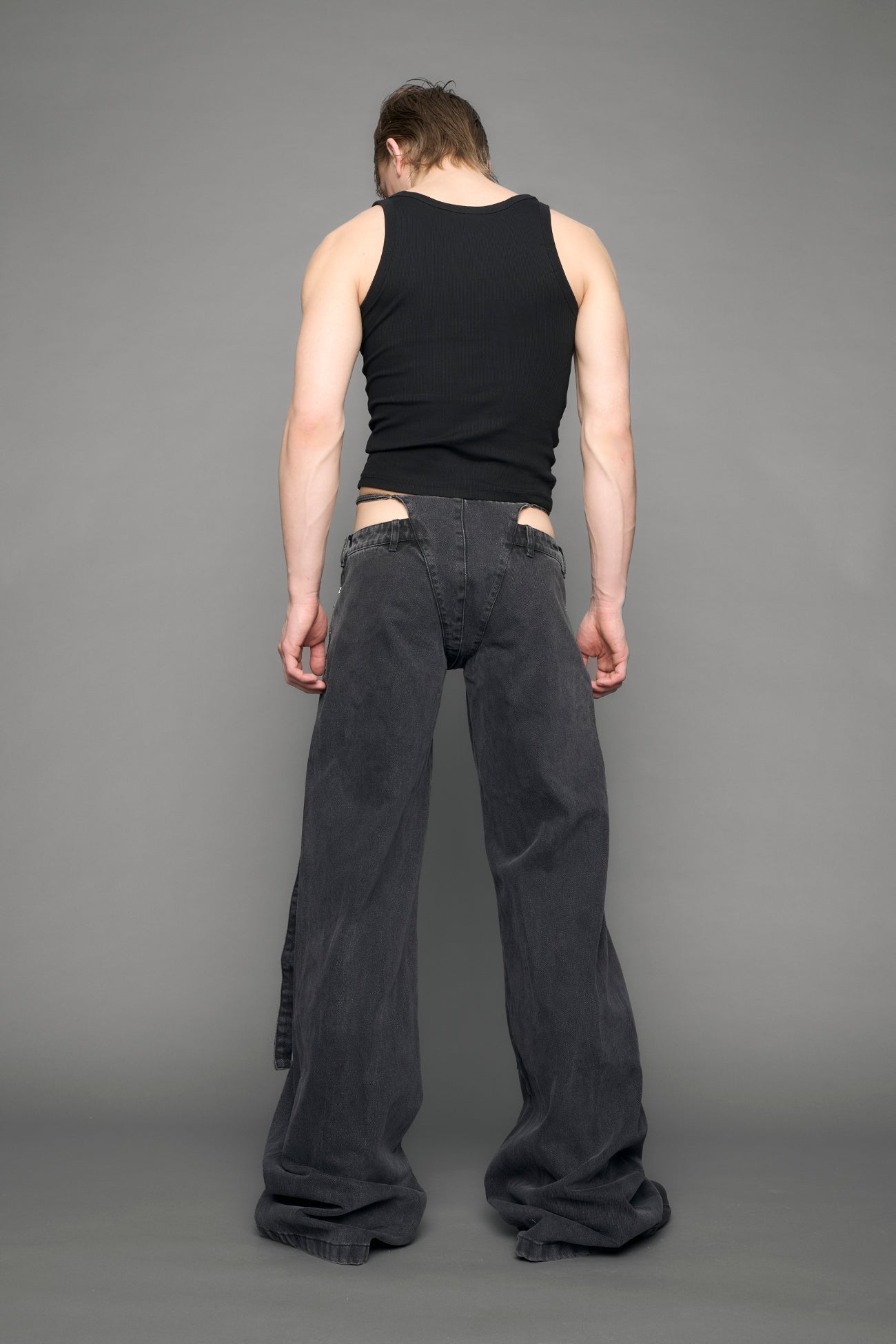 model wearing black grey denim with belt and thong