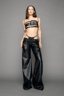 model wearing black vegan leather denim thong pants with belt detail