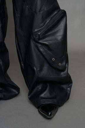 model wearing black vegan leather oversize baggy pants with pocket design details and style lines