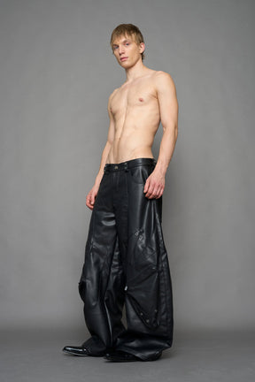 model wearing black vegan leather oversize baggy pants with pocket design details and style lines