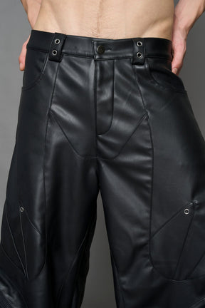 model wearing black vegan leather oversize baggy pants with pocket design details and style lines