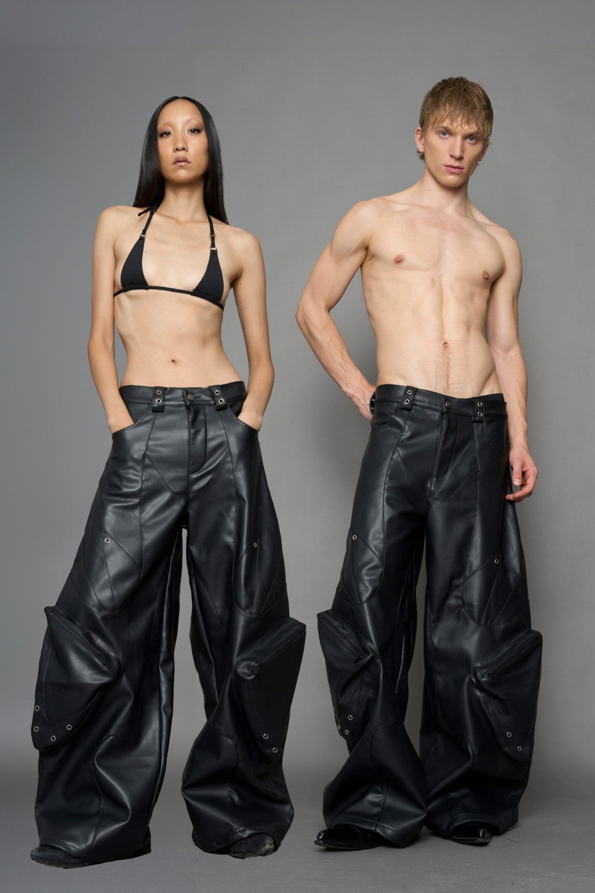 model wearing black vegan leather oversize baggy pants with pocket design details and style lines