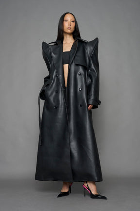 model wearing black vegan leather trench coat with sharp shoulder detail 