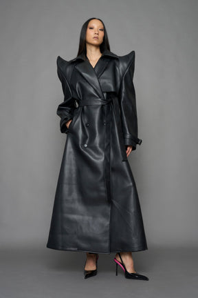 model wearing black vegan leather trench coat with sharp shoulder detail 