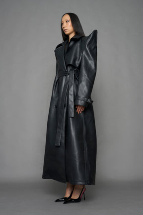 model wearing black vegan leather trench coat with sharp shoulder detail 