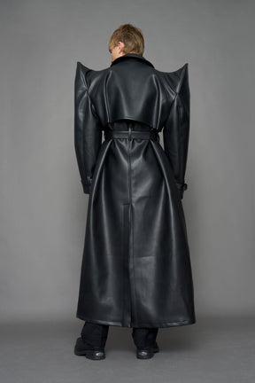 model wearing black vegan leather trench coat with sharp shoulder detail 