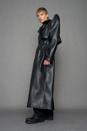 model wearing black vegan leather trench coat with sharp shoulder detail 