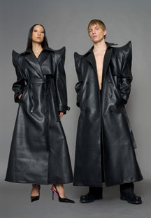 model wearing black vegan leather trench coat with sharp shoulder detail 