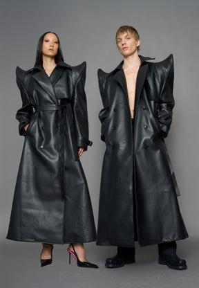 model wearing black vegan leather trench coat with sharp shoulder detail 