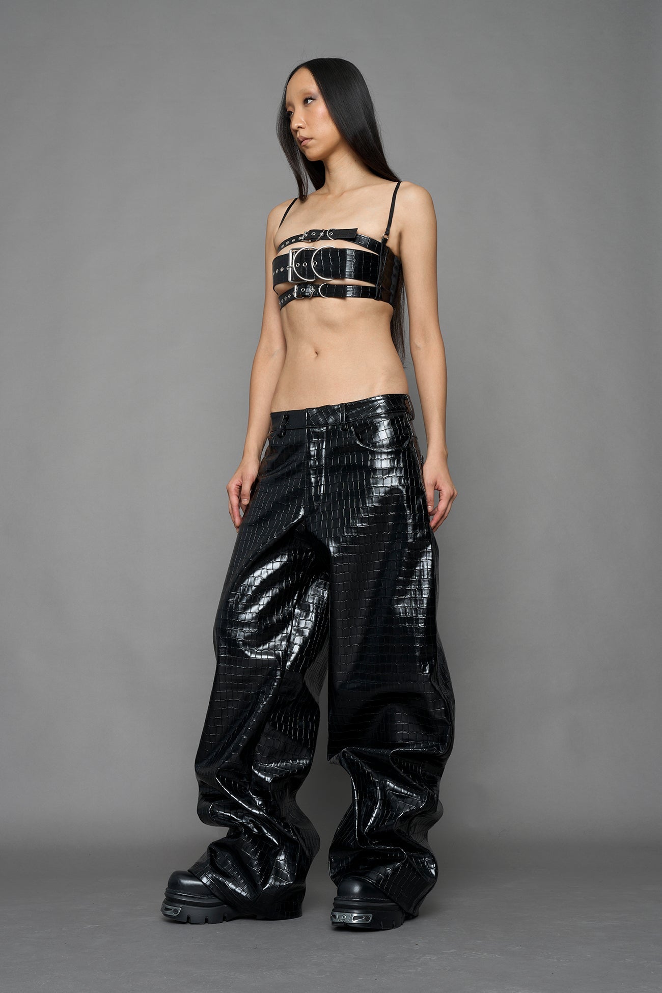 model wearing black vegan leather croc pants