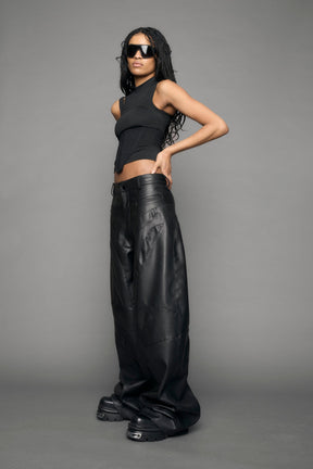 model wearing black vegan leather baggy pants