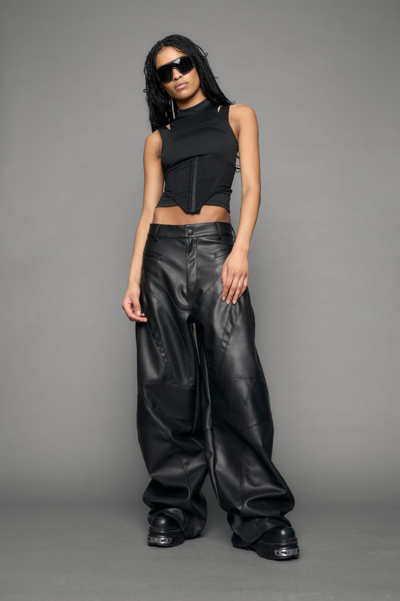 model wearing black vegan leather baggy pants