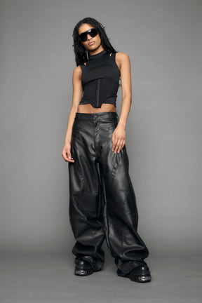 model wearing black vegan leather baggy pants