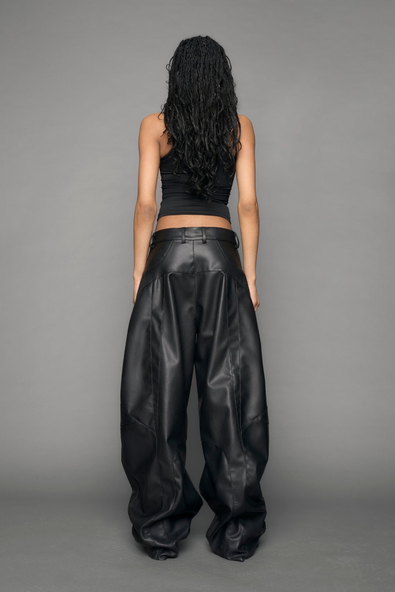 model wearing black vegan leather baggy pants