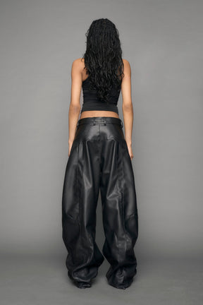 model wearing black vegan leather baggy pants