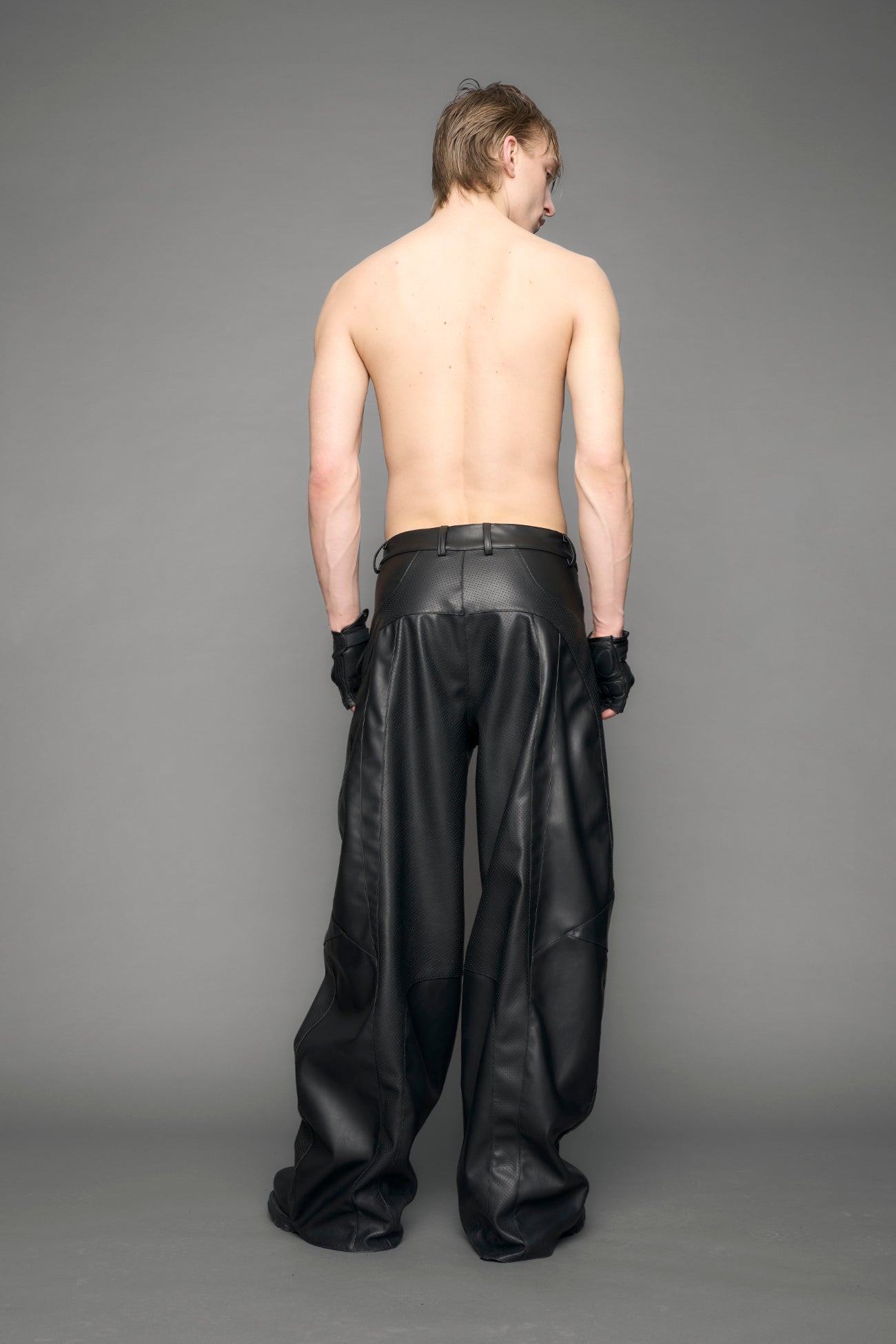 model wearing black vegan leather baggy pants