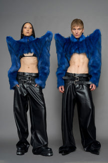 model wearing blue faux fur crop jacket with sharp shoulder design and black pants