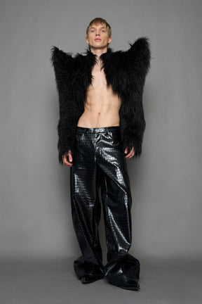 model wearing black faux fur crop jacket with sharp shoulder design and black pants