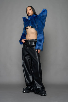 model wearing blue faux fur crop jacket with sharp shoulder design and black pants
