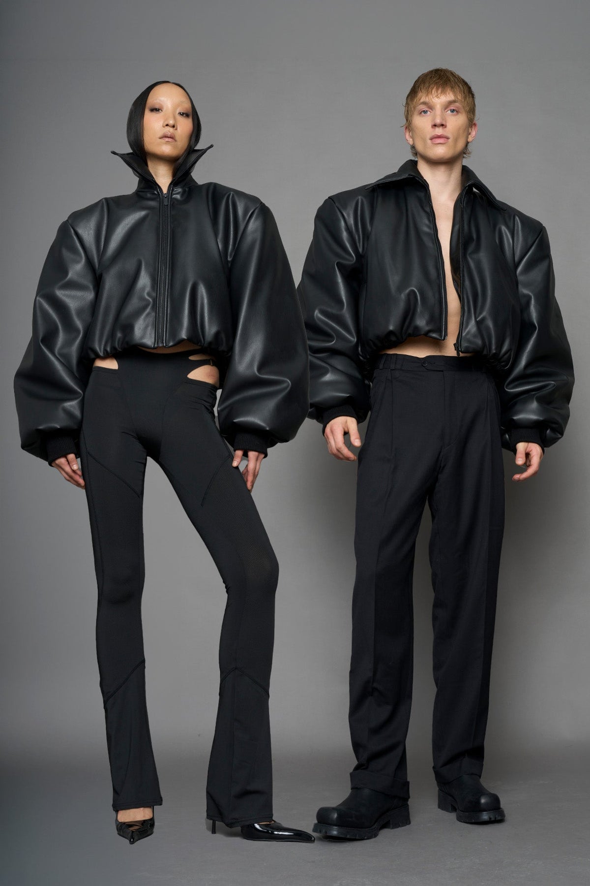 model wearing black puffy faux leather jacket with sharp collar and black pants 