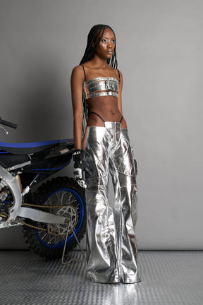silver vegan leather belt top with three adjustable grommet straps, oversized metal buckles, and circular hardware – edgy bondage-inspired crop top for festival or clubwear.