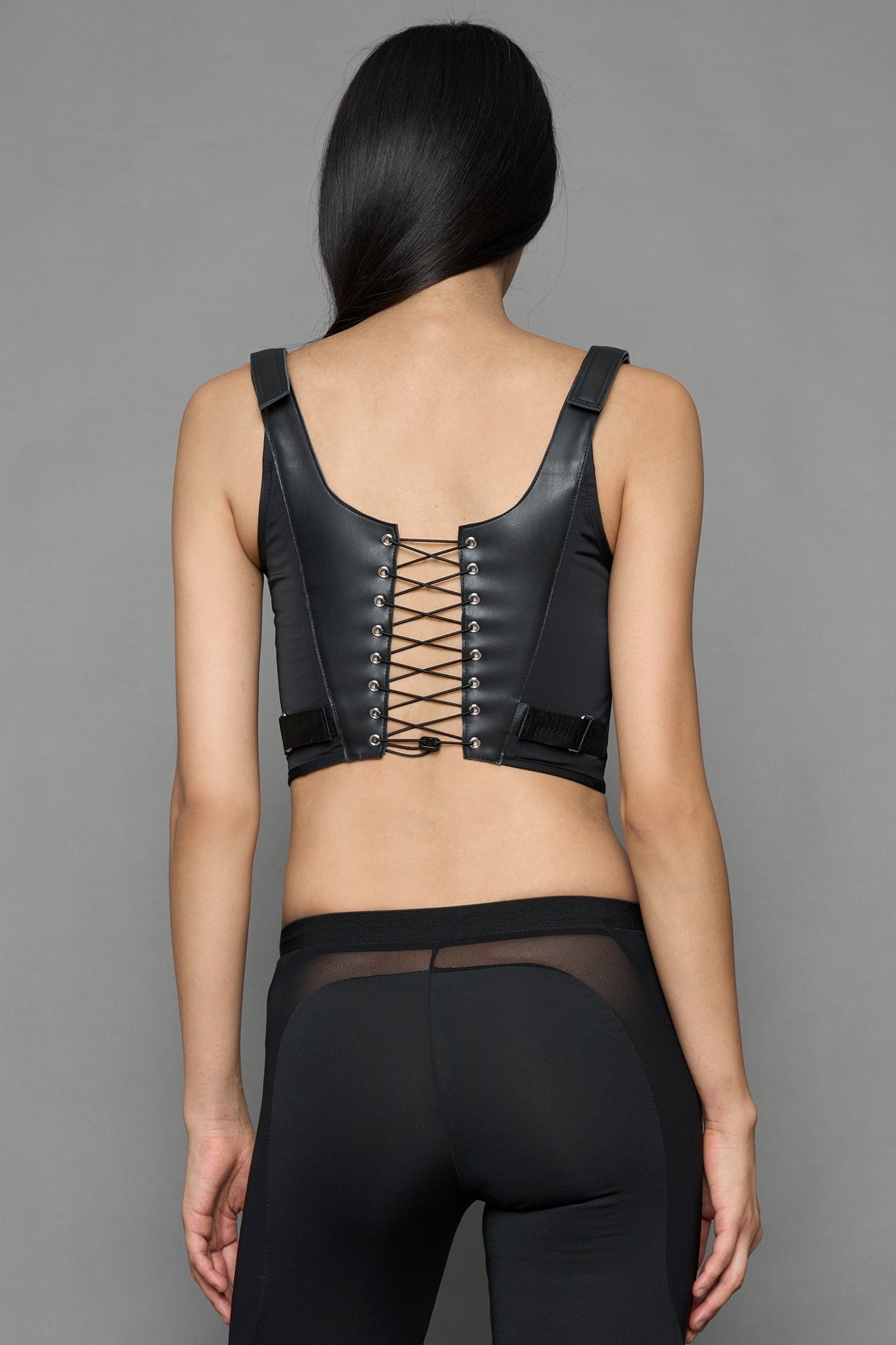 black faux leather lace up corset with sharp design details and buckle and ring details