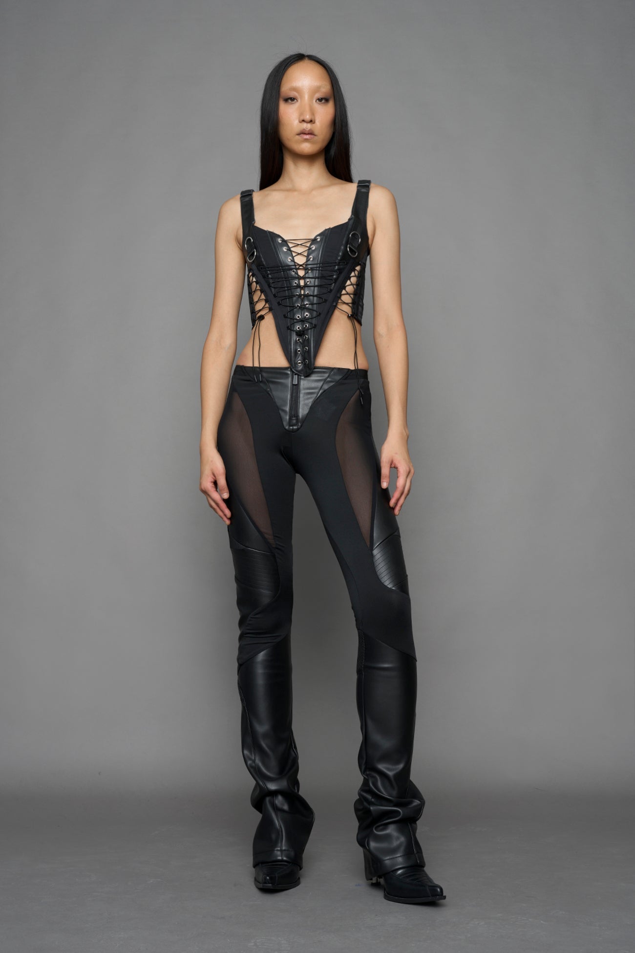 black faux leather lace up corset with sharp design details and buckle and ring details