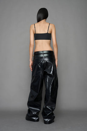model wearing black vegan leather croc optic baggy pants with triple belt design detail