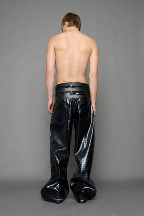 model wearing black vegan leather croc optic baggy pants with triple belt design detail