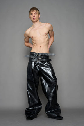 model wearing black vegan leather croc optic baggy pants with triple belt design detail