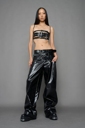 model wearing black vegan leather croc optic baggy pants with triple belt design detail