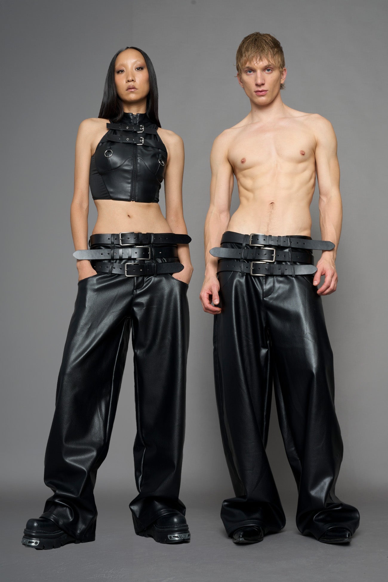 model wearing black vegan leather smooth optic baggy pants with triple belt design detail