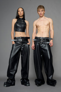 model wearing black vegan leather smooth optic baggy pants with triple belt design detail