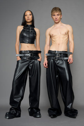 model wearing black vegan leather smooth optic baggy pants with triple belt design detail
