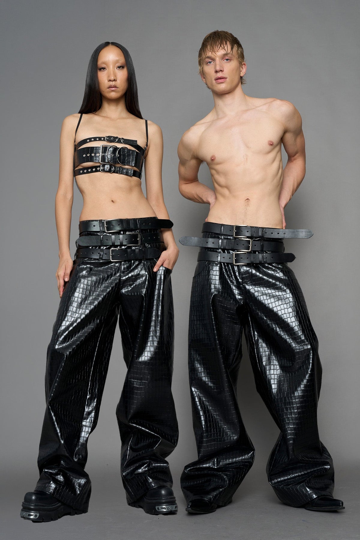 model wearing black vegan leather croc optic baggy pants with triple belt design detail
