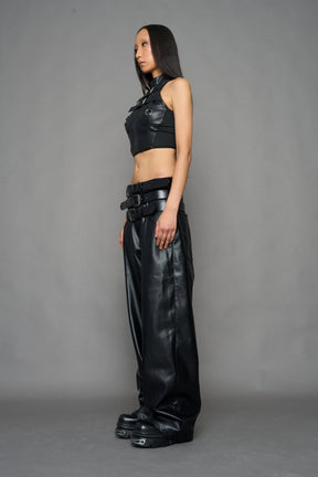 model wearing black vegan leather smooth optic baggy pants with triple belt design detail