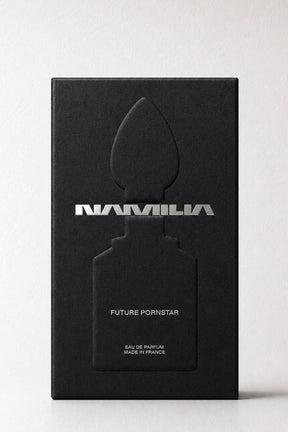 A tall black rectangular box with a large embossed perfume bottle silhouette and the word 'NAMILA' in metallic silver across the front, plus smaller text reading 'FUTURE PORNSTAR' and 'EAU DE PARFUM MADE IN FRANCE,' photographed on a light neutral background.