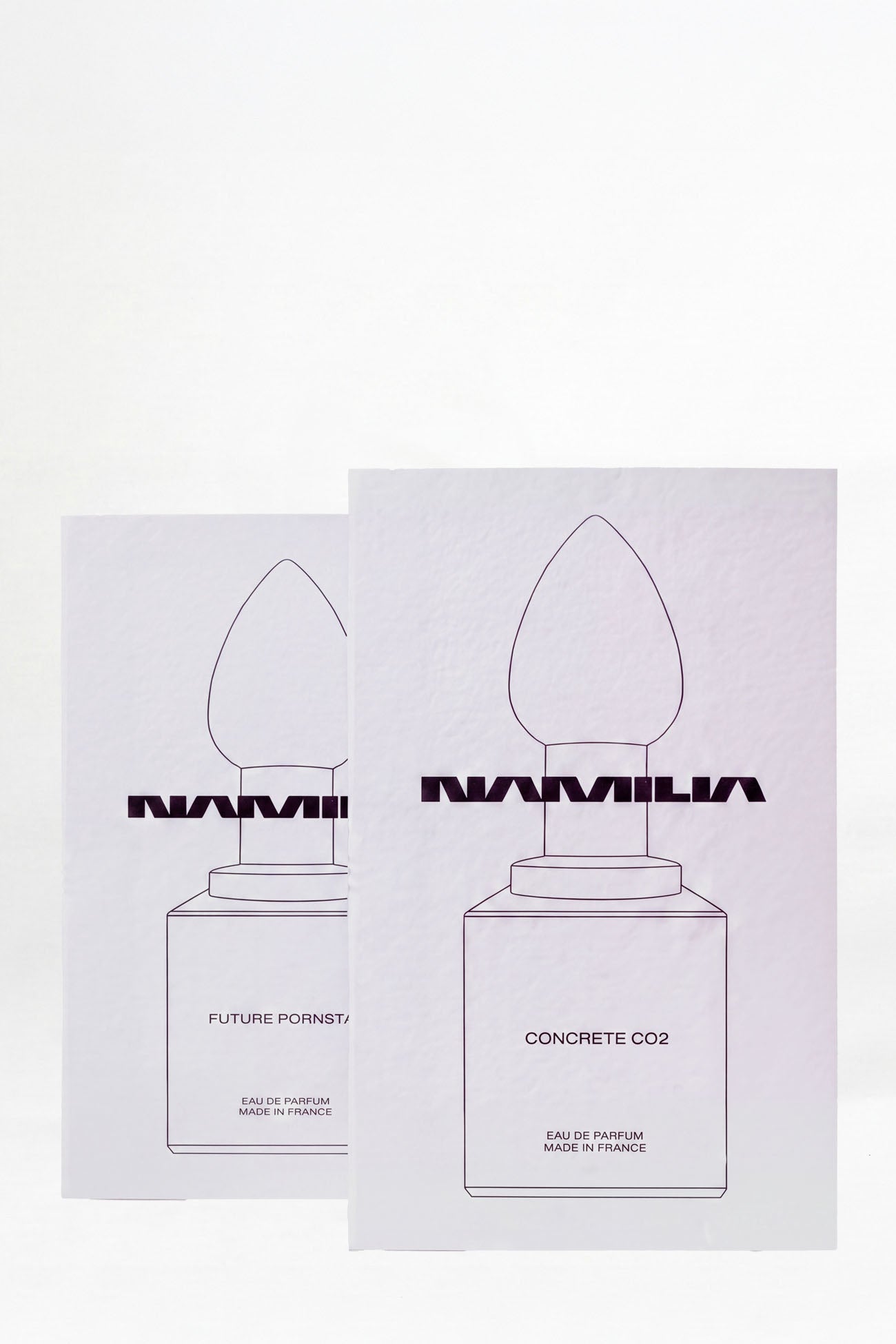 Two small parfum testers. The left vial is labeled 'NAMILIA CONCRETE CO2' and the right vial is labeled 'NAMILIA FUTURE PORNSTAR'.