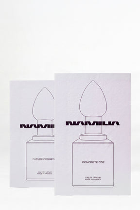 Two small parfum testers. The left vial is labeled 'NAMILIA CONCRETE CO2' and the right vial is labeled 'NAMILIA FUTURE PORNSTAR'.